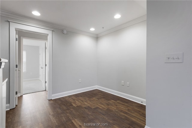 empty room featuring ornamental molding and dark wood-type flooring