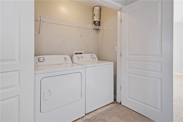 clothes washing area with light colored carpet and washer and dryer