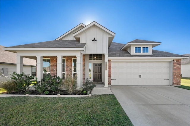 view of front of house featuring a porch, a front yard, and a garage