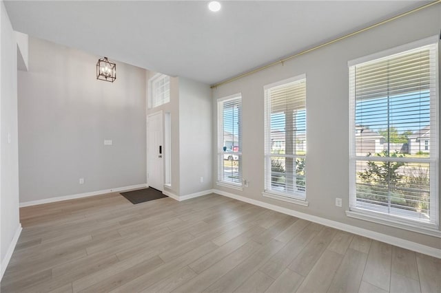 empty room featuring light hardwood / wood-style floors and a chandelier