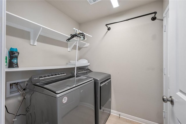 laundry area featuring separate washer and dryer and light wood-type flooring