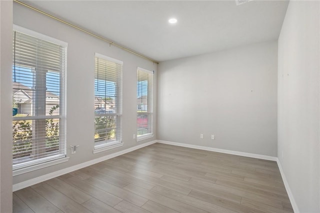 unfurnished room featuring plenty of natural light and light wood-type flooring