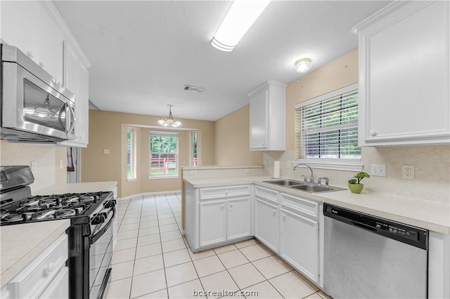 kitchen featuring white cabinets, sink, a notable chandelier, kitchen peninsula, and stainless steel appliances