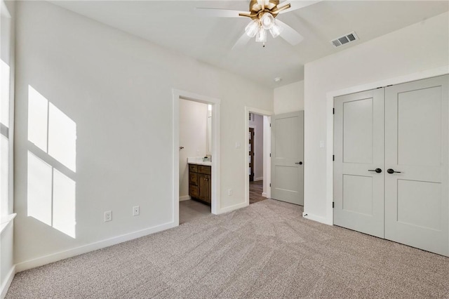 unfurnished bedroom featuring ensuite bathroom, carpet floors, visible vents, baseboards, and a closet