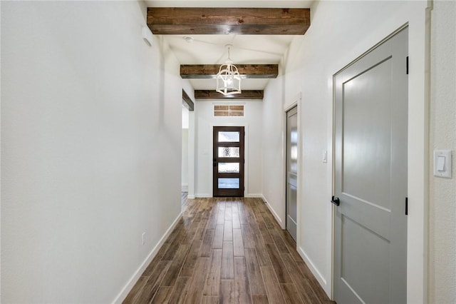 doorway featuring beamed ceiling, dark wood-style flooring, an inviting chandelier, and baseboards