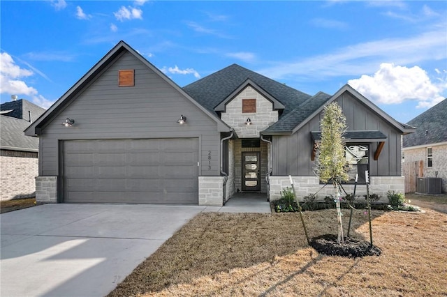 view of front of house with a garage, stone siding, board and batten siding, and concrete driveway