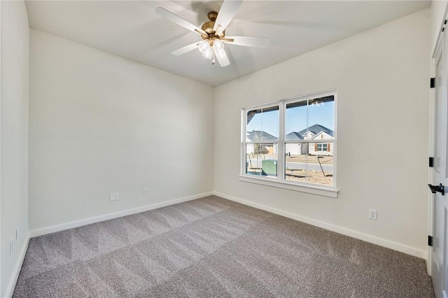 carpeted empty room with a ceiling fan and baseboards