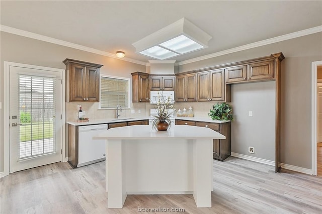 kitchen featuring a center island, backsplash, white dishwasher, ornamental molding, and light hardwood / wood-style floors