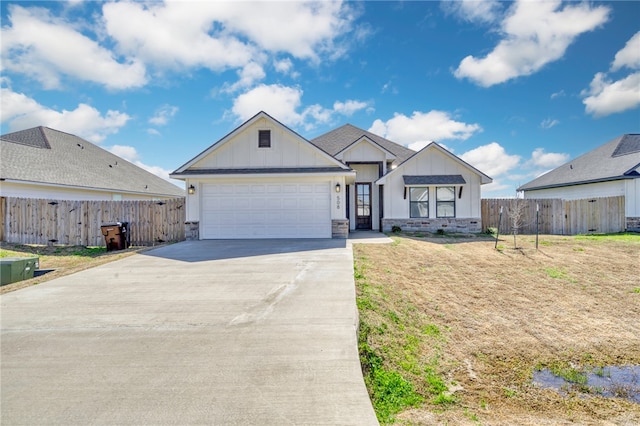 view of front facade with board and batten siding, driveway, a garage, and fence