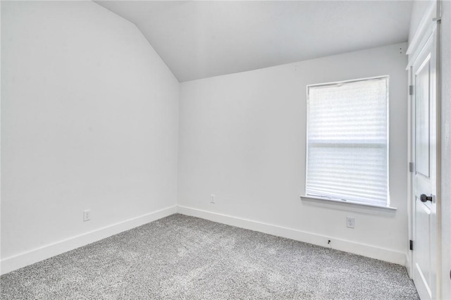 carpeted empty room with lofted ceiling and baseboards