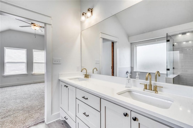 bathroom with double vanity, vaulted ceiling, a ceiling fan, and a sink