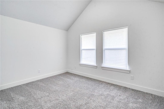 unfurnished room featuring carpet flooring, baseboards, and lofted ceiling