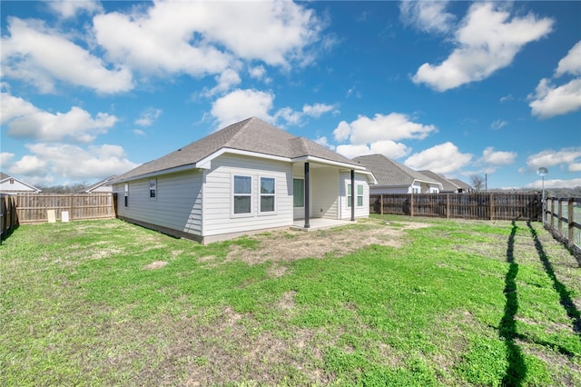 rear view of house featuring a yard, a patio area, and a fenced backyard