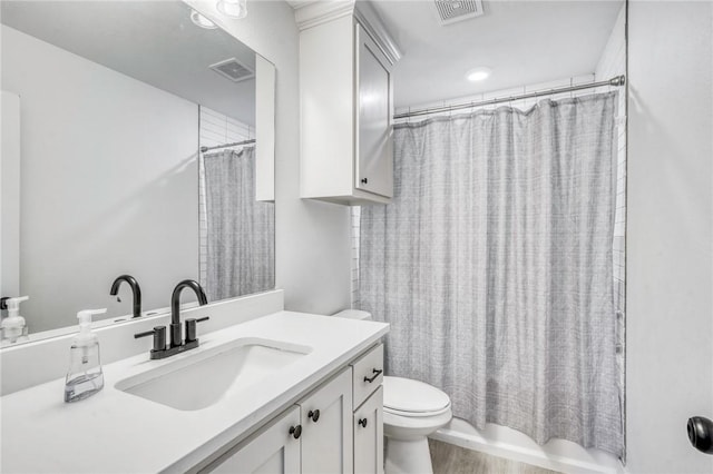 full bathroom featuring visible vents, toilet, wood finished floors, and vanity