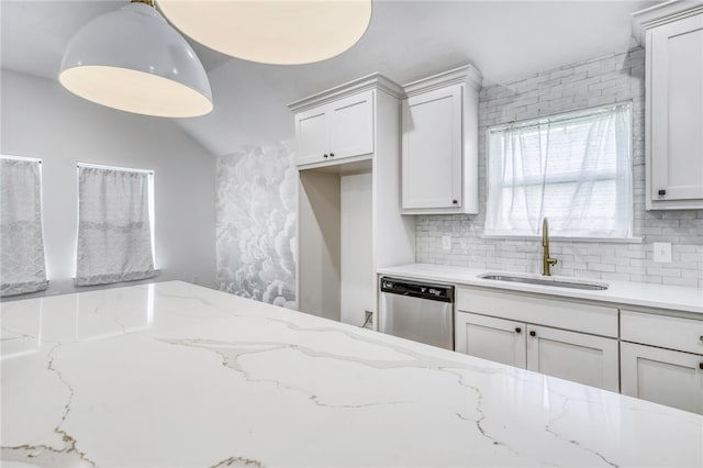 kitchen featuring light stone countertops, a sink, hanging light fixtures, stainless steel dishwasher, and backsplash