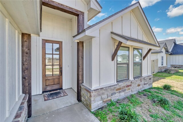 entrance to property featuring stone siding and board and batten siding