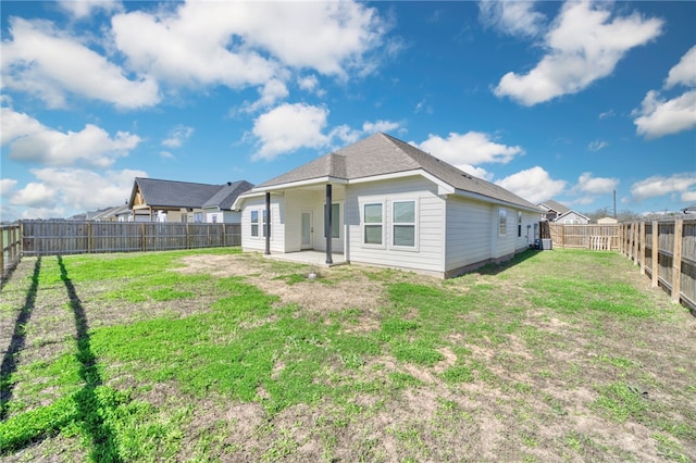 rear view of property with a patio area, a lawn, and a fenced backyard