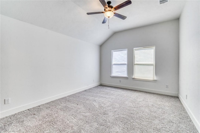 spare room featuring vaulted ceiling, baseboards, carpet floors, and ceiling fan