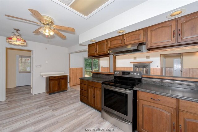 kitchen with stainless steel electric stove, ceiling fan, and light hardwood / wood-style flooring