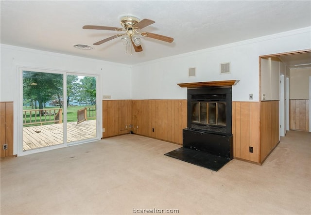 10933 Clyde Accord Rd, Franklin, TX 77856 - unfurnished living room featuring a wainscoted wall, wooden walls, light colored carpet, ceiling fan, and ornamental molding