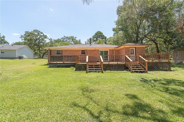 rear view of house featuring a wooden deck and a yard