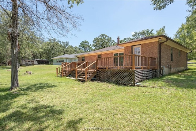 back of property with a lawn and a wooden deck