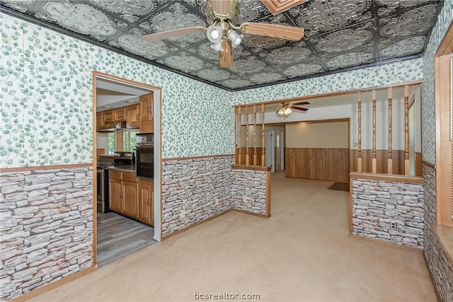 10933 Clyde Accord Rd, Franklin, TX 77856 - spare room with a ceiling fan, wainscoting, wallpapered walls, light colored carpet, and an ornate ceiling