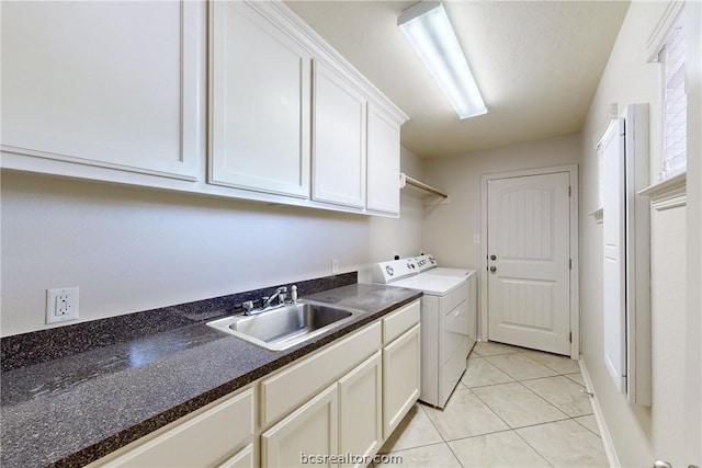 washroom featuring cabinets, light tile patterned flooring, washing machine and clothes dryer, and sink