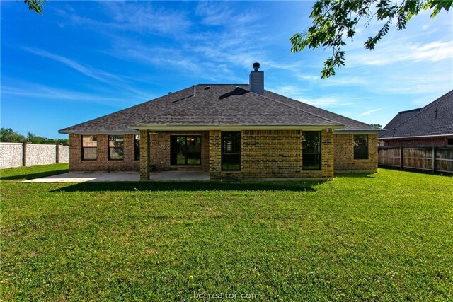 back of house featuring a patio area and a yard