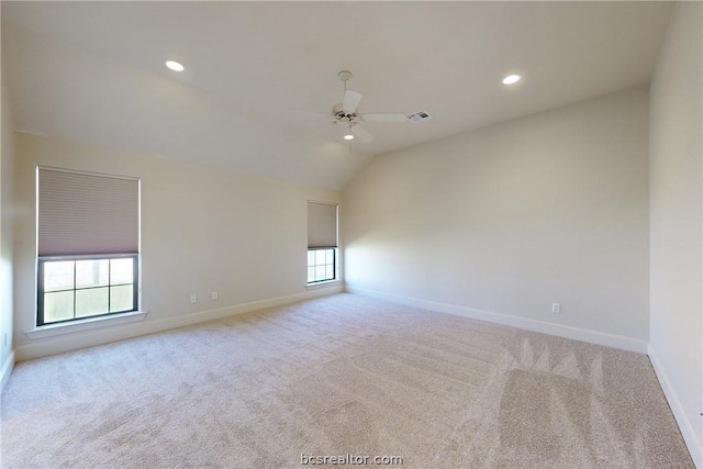 carpeted spare room featuring ceiling fan, a healthy amount of sunlight, and lofted ceiling