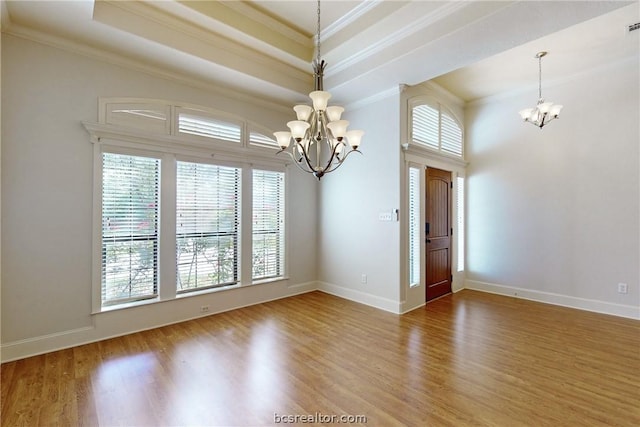 entryway with hardwood / wood-style floors, ornamental molding, and a chandelier