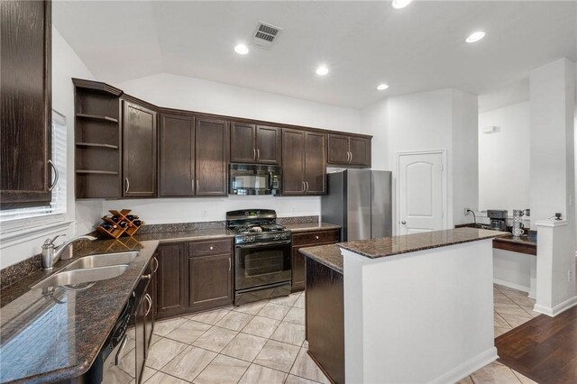 kitchen featuring a kitchen island, sink, dark stone countertops, and black appliances