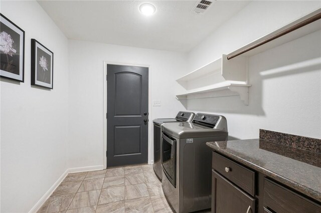 laundry area featuring separate washer and dryer and cabinets