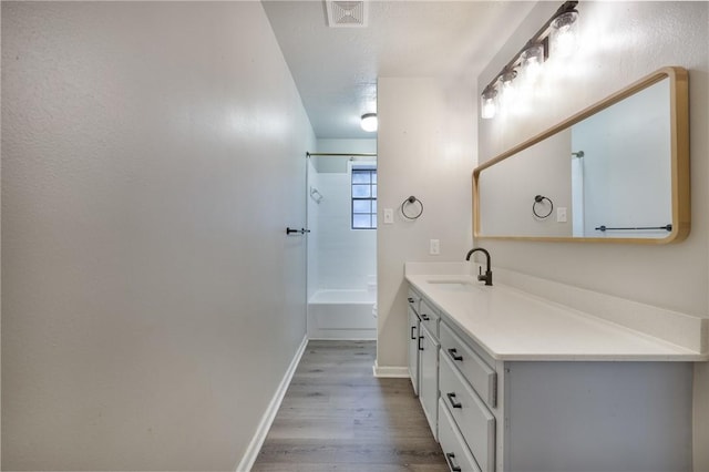 bathroom featuring shower / bath combination, a textured ceiling, vanity, and hardwood / wood-style flooring