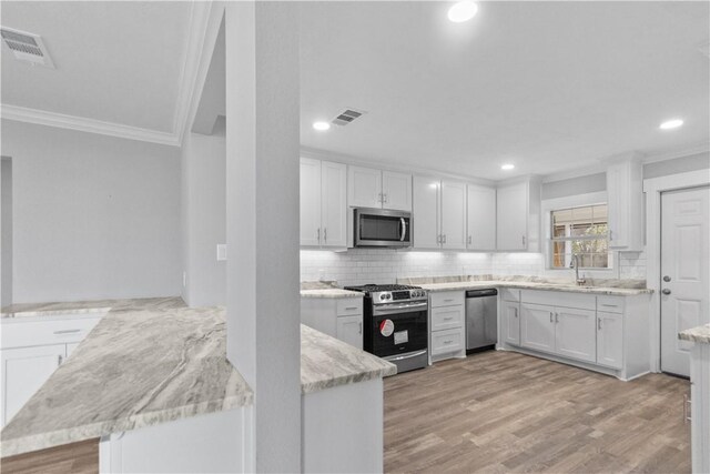 kitchen with stainless steel appliances, visible vents, and white cabinets