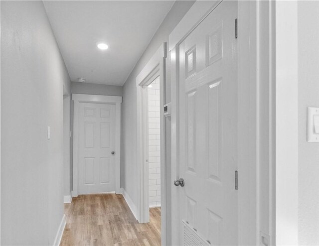 hall with baseboards and light wood-type flooring