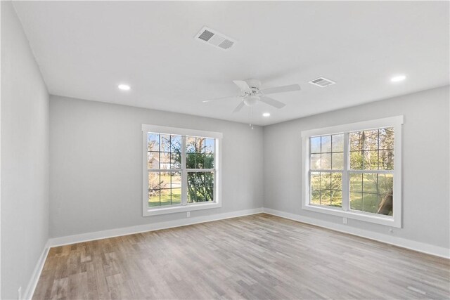 unfurnished room with visible vents, baseboards, and wood finished floors