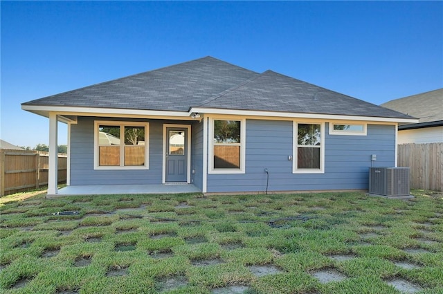 back of property featuring a lawn and central air condition unit