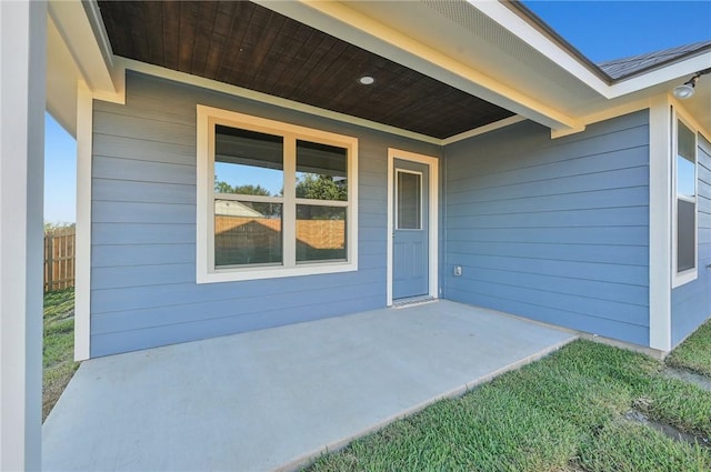 view of exterior entry with a patio area