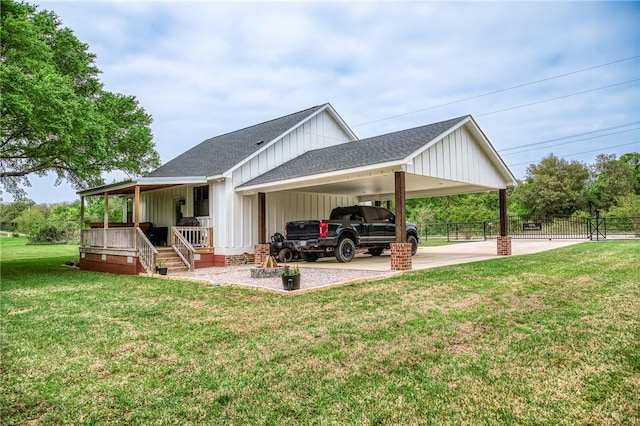 back of property featuring fence, a shingled roof, board and batten siding, a carport, and covered porch