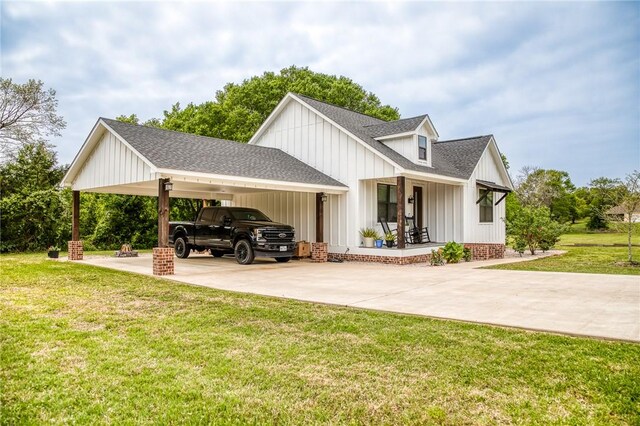 view of property exterior with roof with shingles, an attached carport, a porch, a yard, and driveway