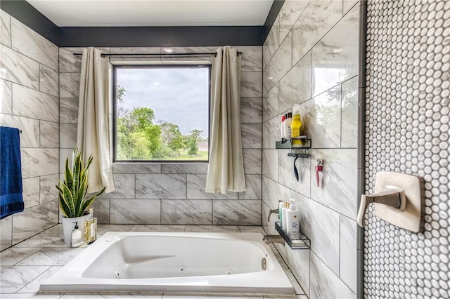 bathroom featuring a whirlpool tub, plenty of natural light, and tile walls