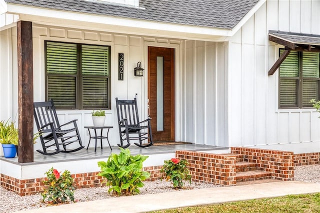 entrance to property featuring a porch, board and batten siding, and a shingled roof