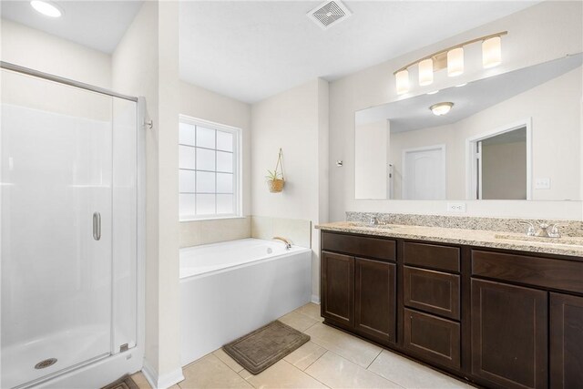 219 Cross Ln, Caldwell, TX 77836 - bathroom with a stall shower, double vanity, a garden tub, and tile patterned flooring