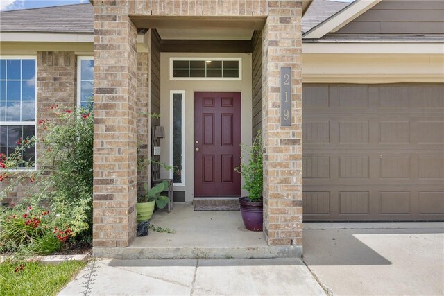 219 Cross Ln, Caldwell, TX 77836 - doorway to property featuring brick siding, driveway, and a garage