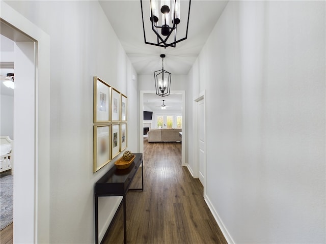 corridor featuring dark hardwood / wood-style flooring and a notable chandelier