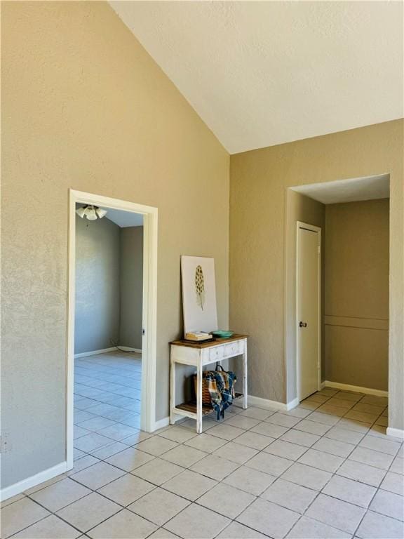 tiled empty room with vaulted ceiling