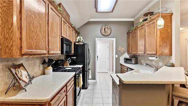 kitchen with a sink, a peninsula, a kitchen bar, backsplash, and black appliances