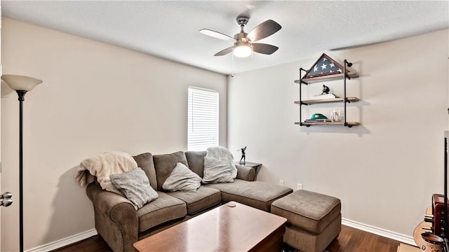 living area featuring ceiling fan, dark wood finished floors, and baseboards