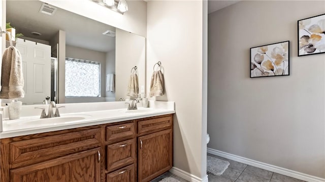 full bathroom featuring a sink, tile patterned flooring, double vanity, baseboards, and visible vents